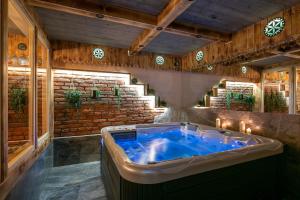 a jacuzzi tub in a room with wooden walls at Góralski Gościniec & SPA in Poronin
