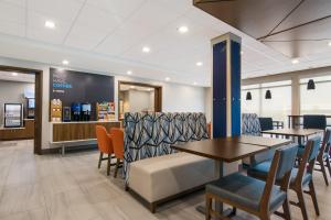 a dining room with tables and chairs and a counter at Holiday Inn Express & Suites - Springdale - Fayetteville Area in Springdale