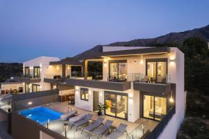 a house with a swimming pool at night at Four Horizons Luxury Villas in Kournás