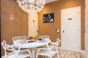 Un comedor con una mesa y sillas blancas. en A-Rome Suite, en Roma 15 fotos más