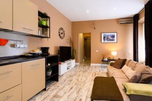Una sala de estar con un sofá y una cocina. en A-Rome Suite, en Roma
