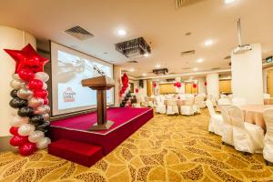 a conference room with a large screen in the middle of a room at Badi'ah Hotel in Bandar Seri Begawan