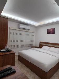 een slaapkamer met een groot wit bed en een bureau bij Petra Family Hotel in Wadi Musa