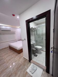 bagno con letto, doccia e servizi igienici di Petra Family Hotel a Wadi Musa
