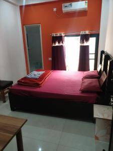 a bedroom with a bed with red sheets and a window at Tapovan Resort in Rishīkesh