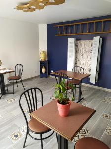 a restaurant with tables and chairs and a potted plant at Entre Terre et Mer - La Clé des Champs in Guisy