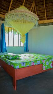 a bedroom with a bed with a canopy and a bedspread with flowers at AFLII Beach Club ( Zanzibar Beach ) in Mtwara