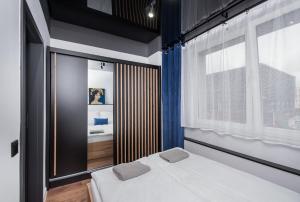 ein Schlafzimmer mit einem Bett und einem großen Fenster in der Unterkunft Apartament Jagielońska 1/3 in Gliwice