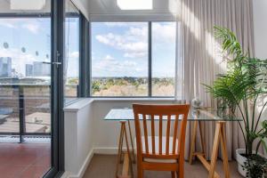 a dining room with a table and chairs and windows at Eliza's Lookout in Perth