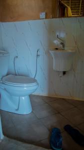 a bathroom with a toilet and a sink at AFLII Beach Club ( Zanzibar Beach ) in Mtwara
