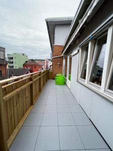 a balcony with a white tile floor and windows at Horten center in Horten