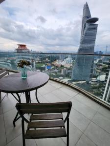 a table and chair on a balcony with a view of a city at KL Gateway Premium Residence near to Mid Valley Bangsar in Kuala Lumpur