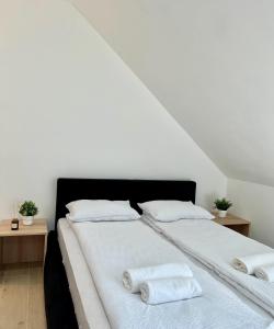 a white bed with two white towels on it at C rooms by Cortado in Zrenjanin