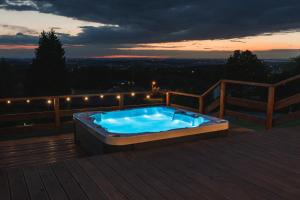 a hot tub sitting on a deck at night at Beskid Glamp in Jaworze
