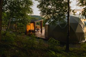 a cabin in the woods with a wooden deck at Beskid Glamp in Jaworze