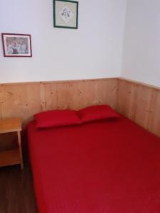 a red bed in a room with a red blanket at PLAGNE-SOLEIL Pied des pistes in La Plagne Tarentaise