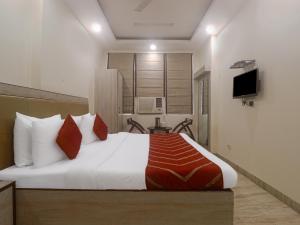 a hotel room with a bed and a television at Hotel Grace, Karol Bagh, New Delhi in New Delhi