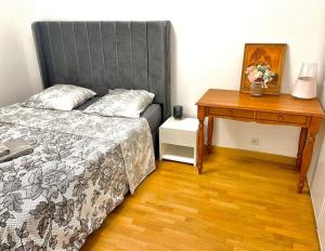 a bedroom with a bed and a nightstand and a table at Un grand deux pièces in Charenton-le-Pont