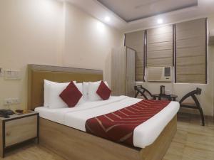 um quarto com uma cama grande e almofadas vermelhas em Hotel Grace, Karol Bagh, New Delhi em Nova Deli