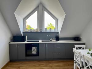 an attic kitchen with a sink and a window at Bałtyckie Klimaty in Stegna