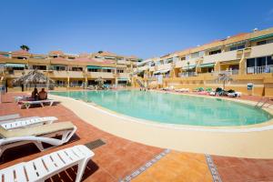 una piscina in un resort con sedie a sdraio di Two bedrooms apartment in Costa Adeje ad Adeje