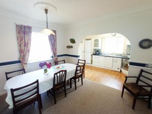 een keuken en eetkamer met een witte tafel en stoelen bij Fjell2Sea in Newcastle