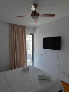 a bedroom with a bed and a flat screen tv at Glyfada Seabreeze Apartment in Athens