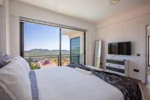 a bedroom with a large bed and a large window at Deniz gören lüks yeni eşyalı ferah 4+1 özel villa in Kas +46 photos