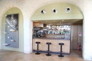 un bar con sgabelli di fronte a un bancone di Apulia Victor Country Hotel ad Alberobello