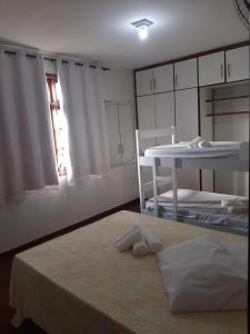um quarto com uma cama, uma mesa e uma janela em Hostel Salvador Orquídeas em Salvador
