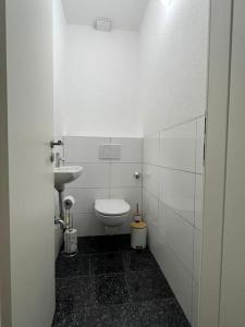 a white bathroom with a toilet and a sink at Zentrale Düsseldorf City 2 Zimmerwohnung in Düsseldorf