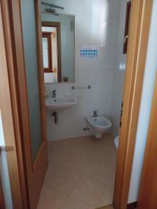 bagno con lavandino, servizi igienici e specchio di Tirano in relax a Tirano