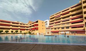 ein großes Schwimmbad vor einem Gebäude in der Unterkunft los Gigantes Jardines del Mar in Puerto de Santiago