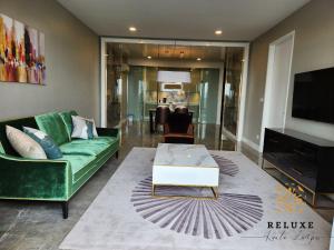a living room with a green couch and a coffee table at The Platinum 2 KLCC Premium Suite by Reluxe Kuala Lumpur in Kuala Lumpur