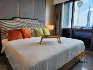 a bedroom with a bed with a table on it at The Platinum 2 KLCC Premium Suite by Reluxe Kuala Lumpur in Kuala Lumpur