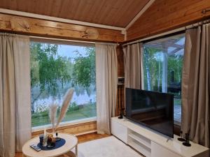 Il comprend un salon doté d'une grande fenêtre et d'une télévision à écran plat. dans l'établissement Villa Kastehelmi, à Suonenjoki