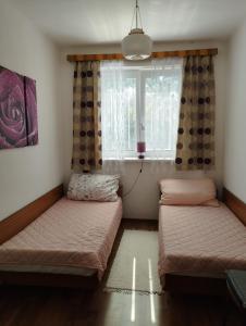 2 camas en una habitación con ventana en Rodinný dom u Veroniky, en Snina