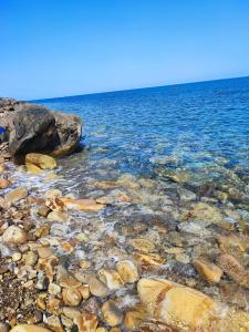 a beach with rocks and the water at Soleli in Molino San Biagio