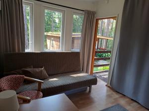 Zakątek Mazurski GIM في Teerau: غرفة معيشة مع أريكة ونافذة