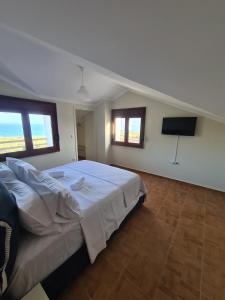 a bedroom with a bed and a flat screen tv at Majestic View Resort in Nafpaktos