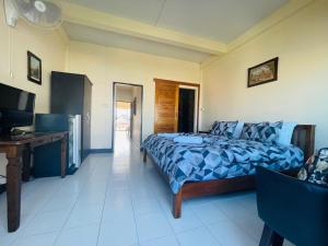 華欣的住宿－索菲亞酒店，一间卧室配有一张床、一张书桌和一台电视