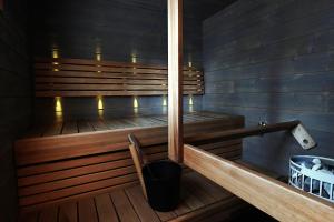 a wooden sauna with a bench and a bucket at Levillenet Levi centre chalets in Levi