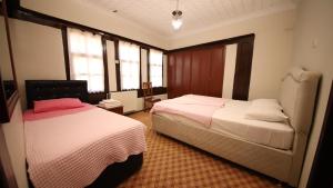 a bedroom with two beds and two windows at Dibekönü Konak in Safranbolu