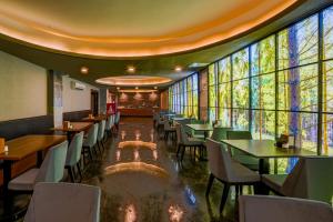 een restaurant met tafels en stoelen en grote ramen bij Lupo Libero Hotel Spa in Antalya