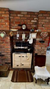 - une cuisine avec un mur en briques et une cuisinière dans l'établissement The Old Post Office Lodge, à Enniskillen