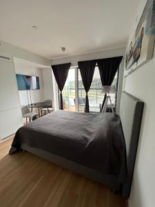 een slaapkamer met een bed, een bureau en een raam bij Koselig studioleilighet in Jessheim