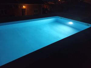 una piscina con luces azules en la oscuridad en Piscina privada - V3 - Internet Fibra, en Teixoso