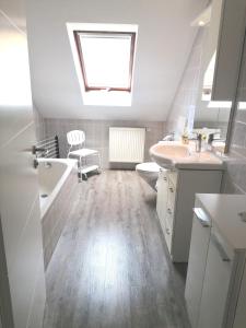 een badkamer met een wastafel, een toilet en een dakraam bij Ferienwohnung Rheintal in Kappel-Grafenhausen