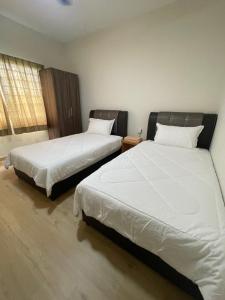 Duas camas sentadas uma ao lado da outra num quarto em SEA LA VIE SWEET @ NAUTICA RESORT em Porto Dickson