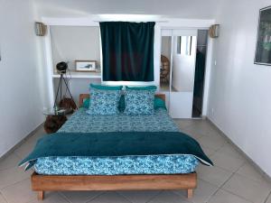 um quarto com uma cama grande e almofadas azuis em vert lagon em Saint-Pierre
